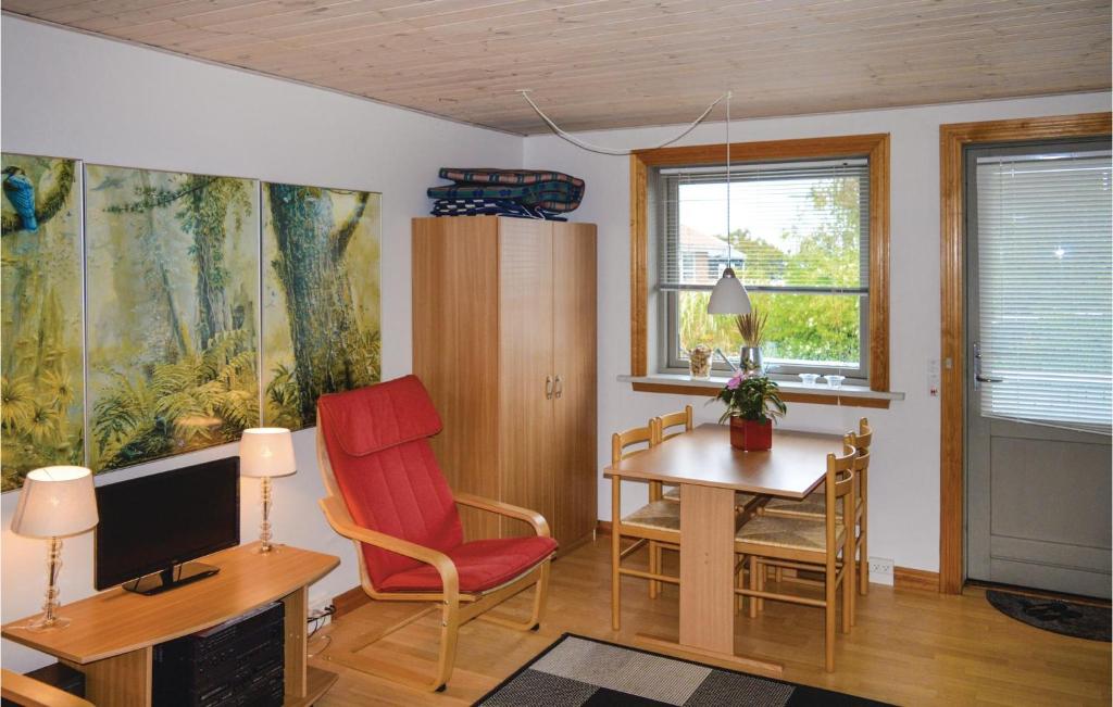 スケーエンにあるStunning Studio In Skagen With Wifiのリビングルーム(デスク、赤い椅子付)
