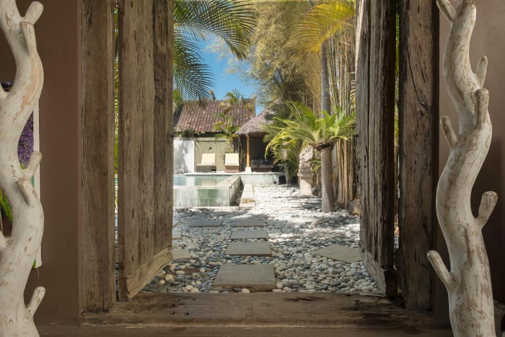 an alleyway leading to a house with palm trees at Seminyak Villa in Seminyak