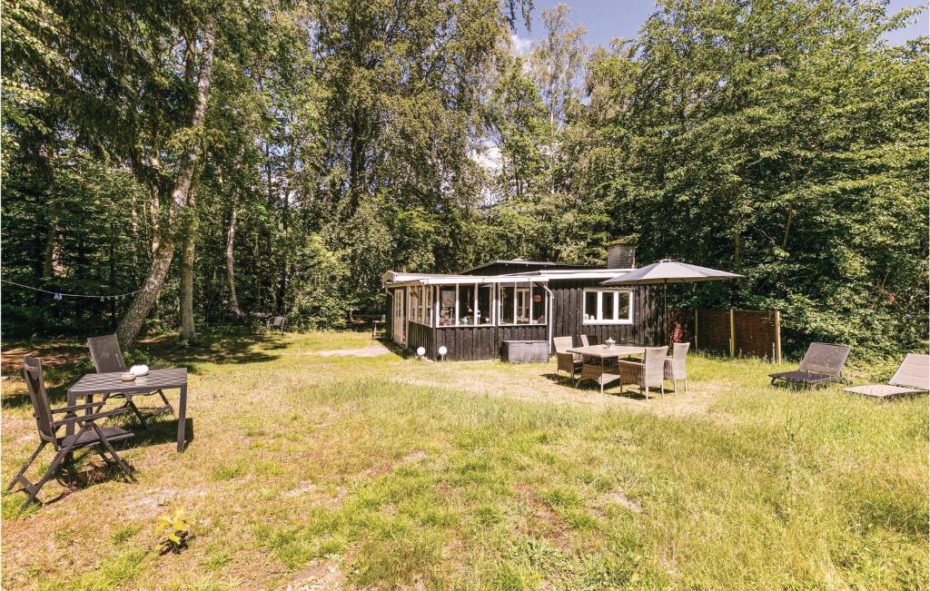einen Pavillon mit einem Tisch und einem Picknicktisch im Hof in der Unterkunft Borkjehuzed in Rønne