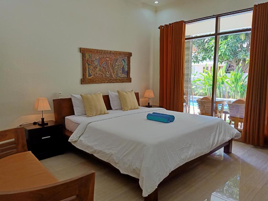 a bedroom with a bed with a blue box on it at Two Brothers Villa in Gili Air
