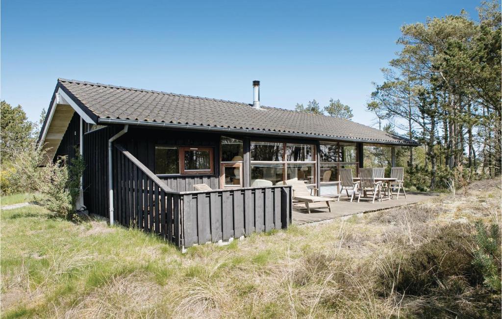 ÅlbækにあるAmazing Home In lbk With 3 Bedrooms, Sauna And Wifiの野原のデッキ付黒家
