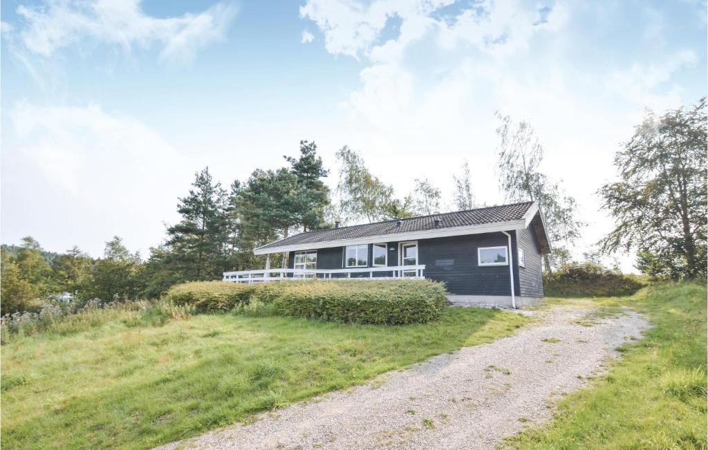 a small house on a hill with a dirt road at Cozy Home In Ebeltoft With Sauna in Femmøller
