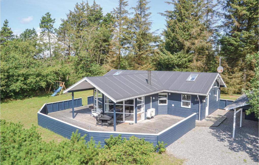 a blue house with a deck and a playground at Awesome Home In Nrre Nebel With 5 Bedrooms, Sauna And Wifi in Lønne Hede