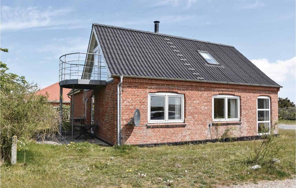HarboørにあるNice Home In Harbore With 3 Bedroomsのレンガ造りの家で、バルコニーが横にあります。