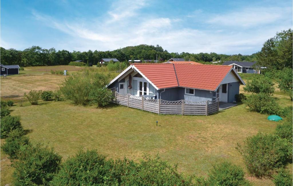 a house with a red roof in a field at 2 Bedroom Awesome Home In Hovborg in Hovborg