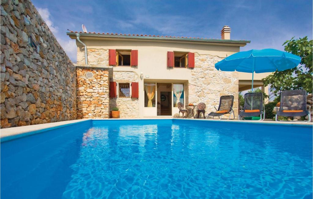a villa with a swimming pool in front of a house at Nice Home In Krk With Outdoor Swimming Pool in Garica