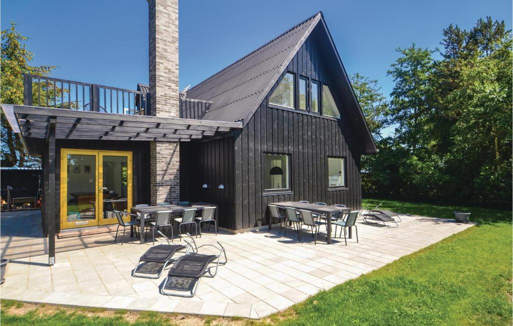 una casa con mesas y sillas en un patio en 6 Bedroom Stunning Home In Grenaa, en Grenå