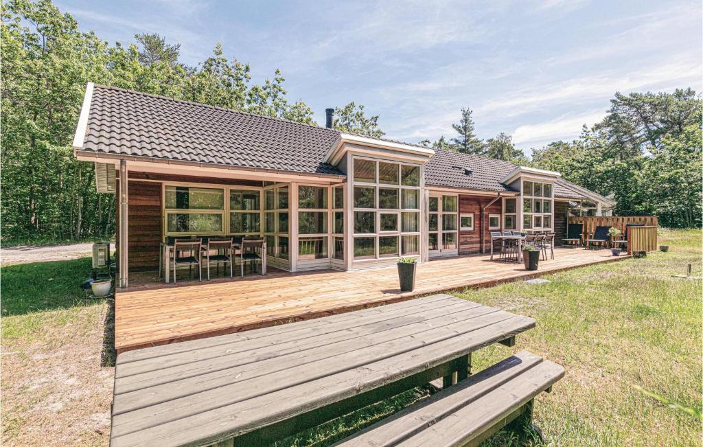 Casa con terraza de madera con mesa en Rubinsen Skovhuse, en Hasle
