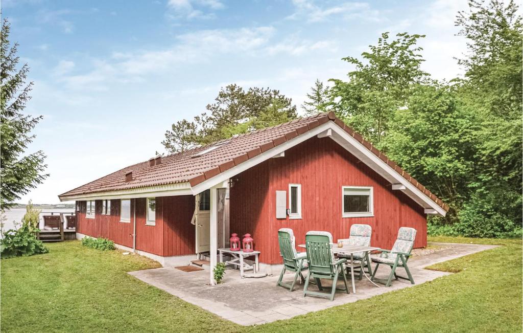 SkibbyにあるTwo-Bedroom Holiday Home In Skibbyの赤いコテージ(テーブル、椅子付)