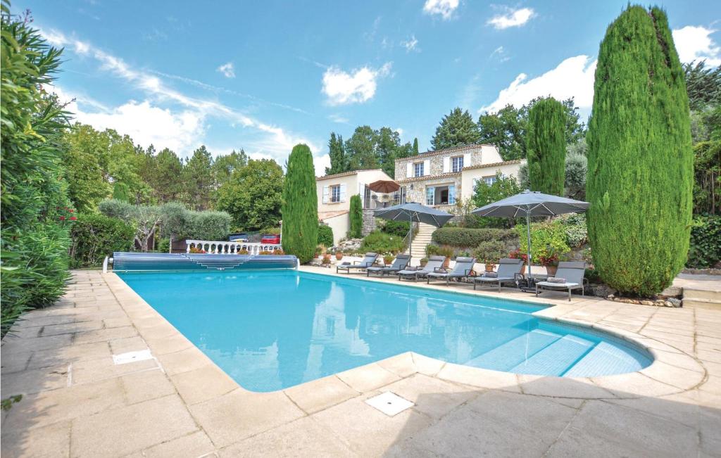 a swimming pool in a yard with trees and a house at 4 Bedroom Cozy Home In Montauroux in Montauroux