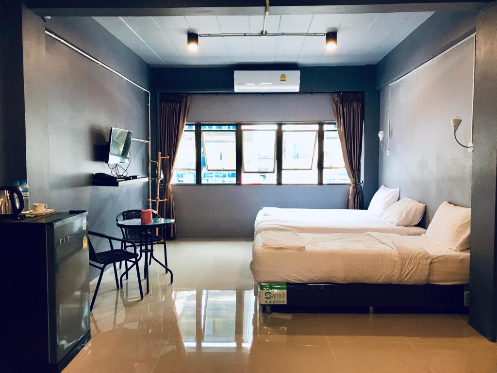 een slaapkamer met een bed, een tafel en een stoel bij SleepCatsHostel in Bangkok