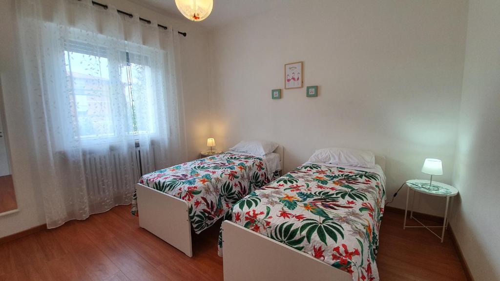 1 dormitorio con 2 camas y ventana en Residenza Chiara, en Forlì