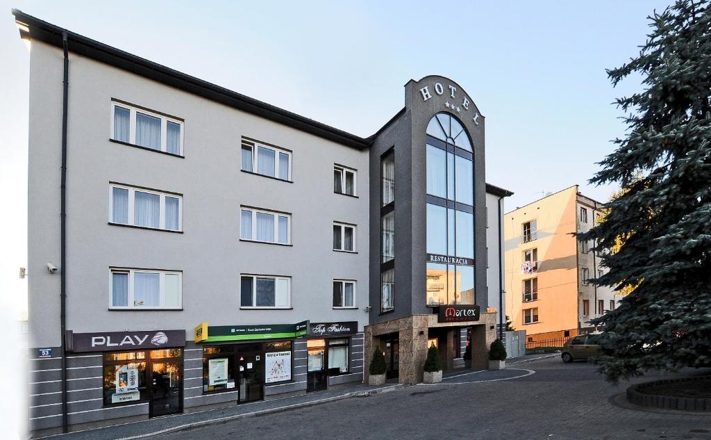 un edificio con un reloj al costado. en Hotel Martex, en Płońsk