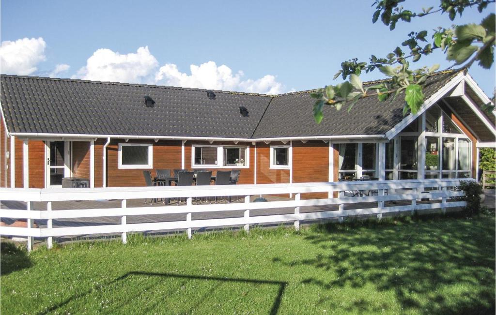 ein Haus mit einem weißen Zaun davor in der Unterkunft 4 Bedroom Amazing Home In Bog By in Bogø By