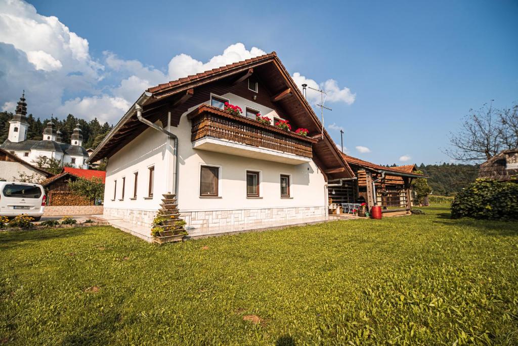 a white house with a roof on a grass field at Holiday Home Mountain View in Ljubno