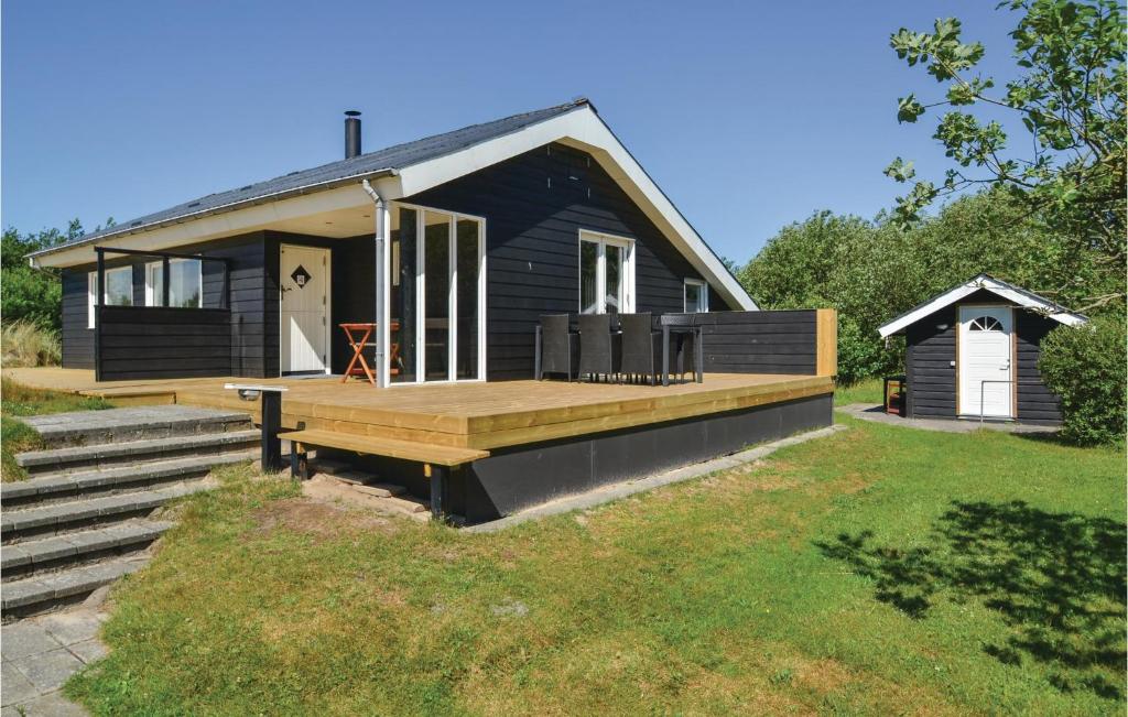 ein kleines schwarzes Haus mit einer Veranda und einer Terrasse in der Unterkunft Beautiful Home In Fan With Wifi in Fanø