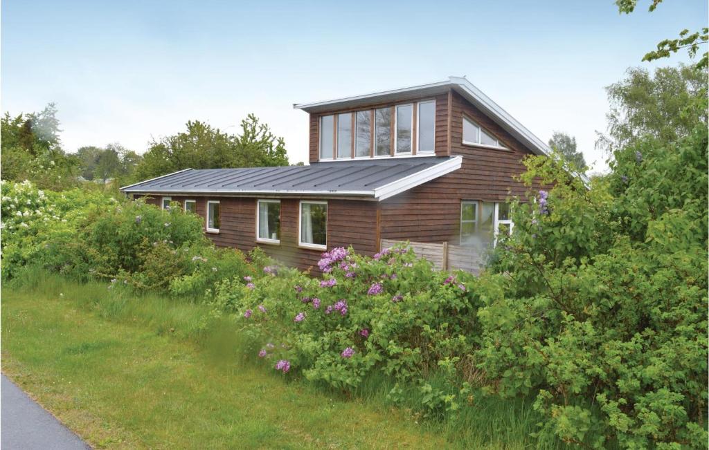 une maison avec un toit noir et quelques buissons dans l'établissement Amazing Home In lsted With Kitchen, à Ølsted