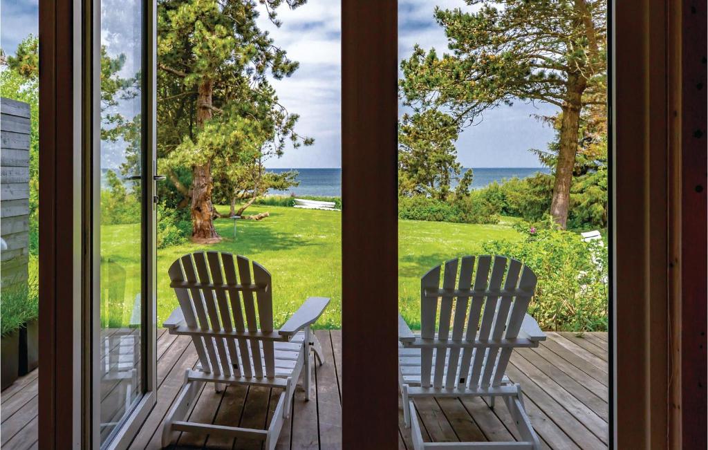 two chairs sitting on a porch looking out at the ocean at Stunning Home In Kalundborg With Kitchen in Kalundborg