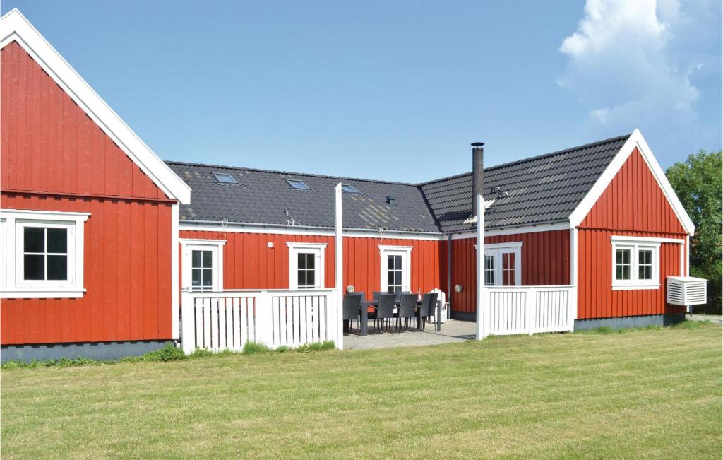 a row of red barns with a yard at Tisvildelund in Vejby