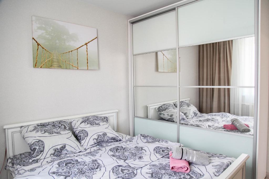 a bedroom with a mirror and a bed at MANGO- апартаменты БЕЛЫЕ НОЧИ в Кобрине in Kobryn