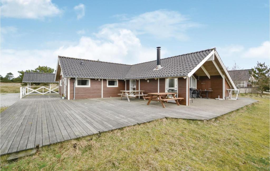 una casa con una terraza de madera frente a ella en Stunning Home In Fan With 4 Bedrooms, Sauna And Wifi, en Fanø