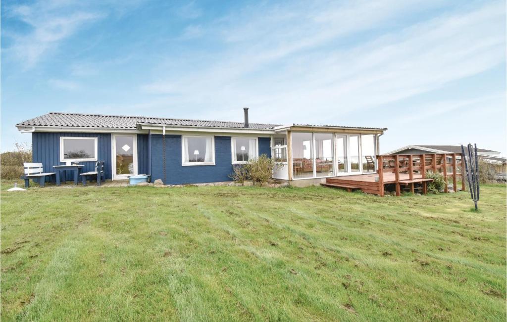 uma casa azul com um deque num campo em Stunning Home In Ebberup With Kitchen em Helnæs By