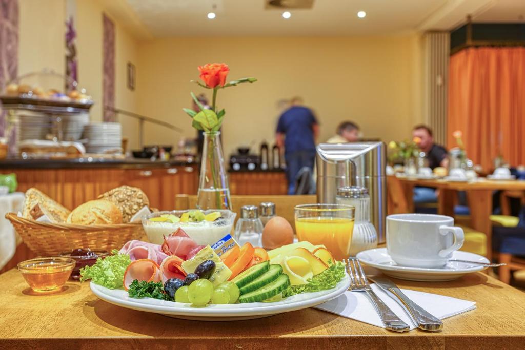 a table with a plate of food on a table at Centro Hotel Braunschweig City, Trademark Collection by Wyndham in Braunschweig