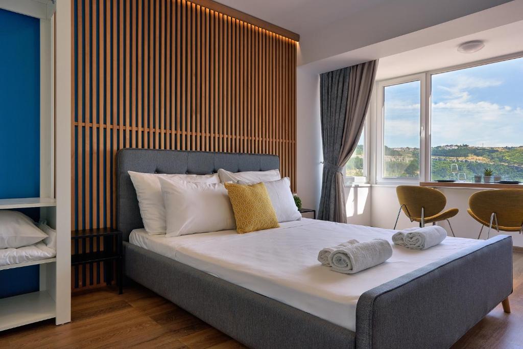 um quarto com uma cama e uma grande janela em Adel Apartments em Veliko Tŭrnovo