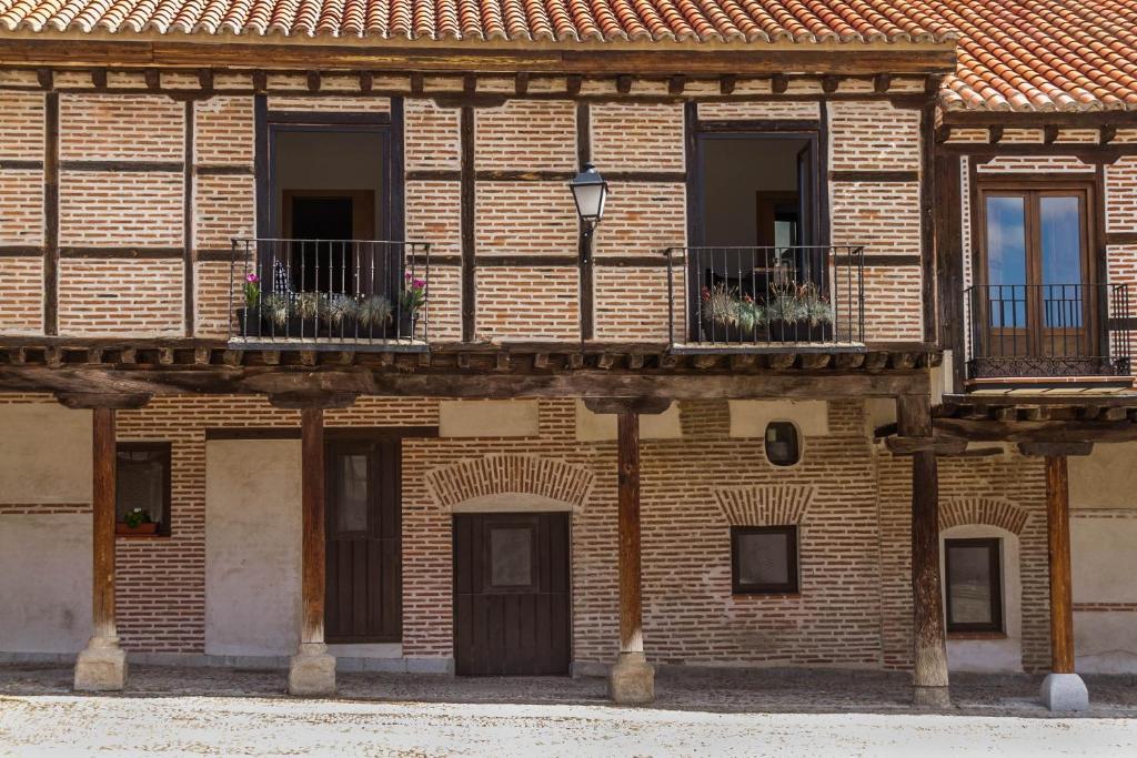 un edificio de ladrillo con balcones y flores. en Mi Villa Arévalo, en Arévalo