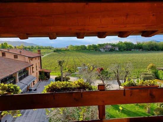 uma vista para um campo a partir de uma janela de uma casa em AGRITURISMO RIPA DEL BOSCO em Capriolo