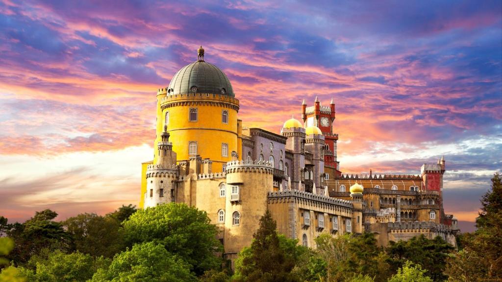 ein großes Schloss mit Sonnenuntergang im Hintergrund in der Unterkunft Villa Lunae - Sintra Flats in Sintra