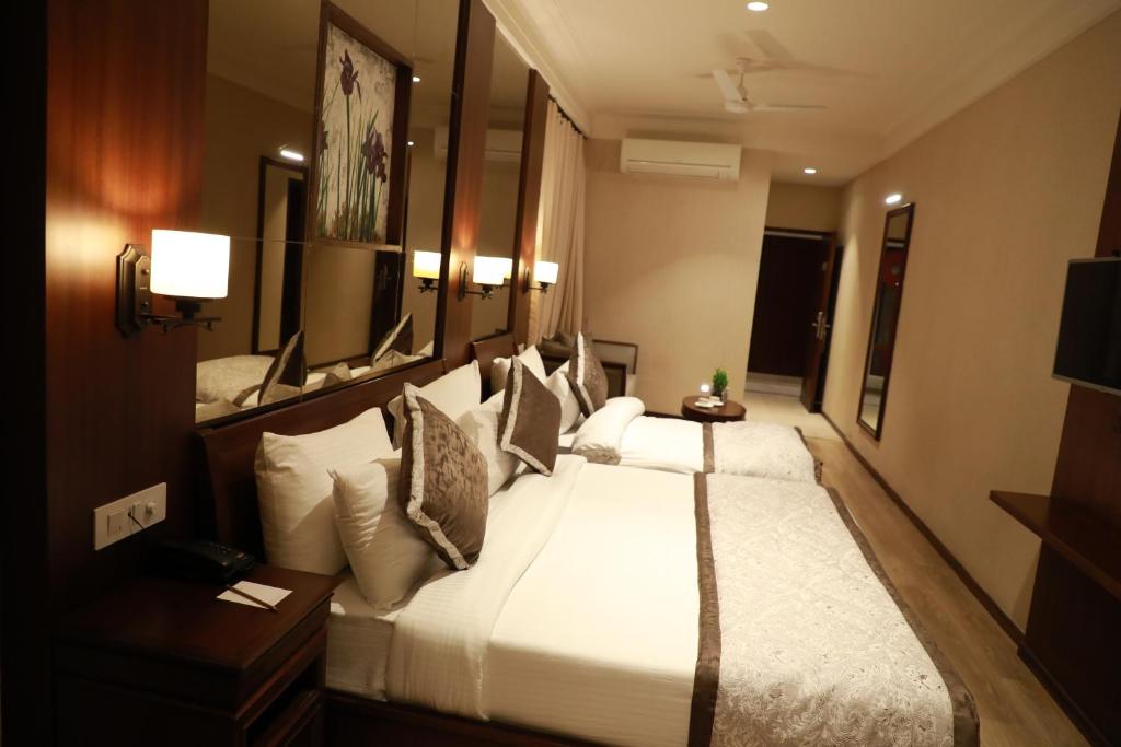 a bedroom with a large white bed with pillows at Hotel Golden Tower Near Heritage Street in Amritsar
