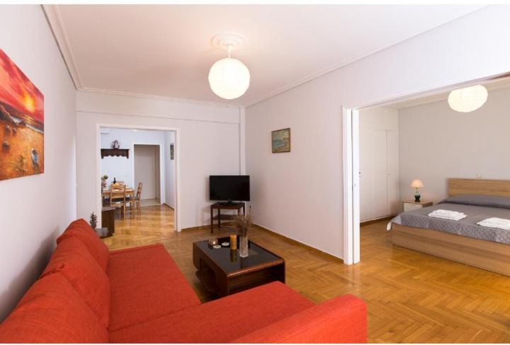 a living room with a red couch and a bed at Christina's flat in Athens