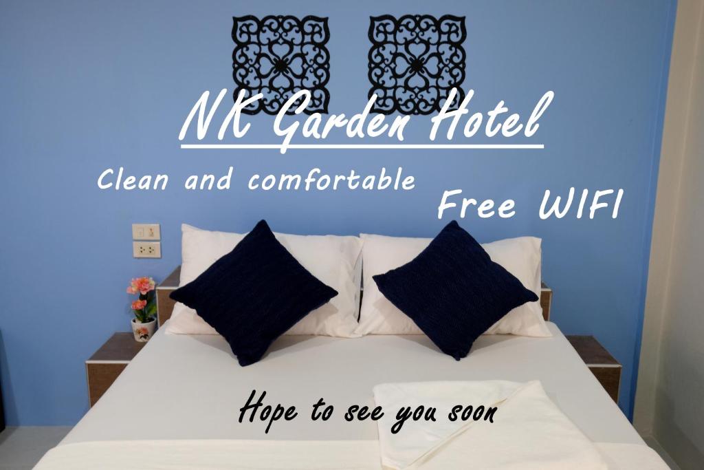 Un dormitorio con una cama con una señal de hotel mr garden en NK Garden Hotel @Suratthani Airport en Surat Thani