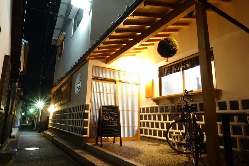 Una bicicleta estacionada fuera de un restaurante por la noche en Kakure-Yado Yuji-inn, en Kurashiki