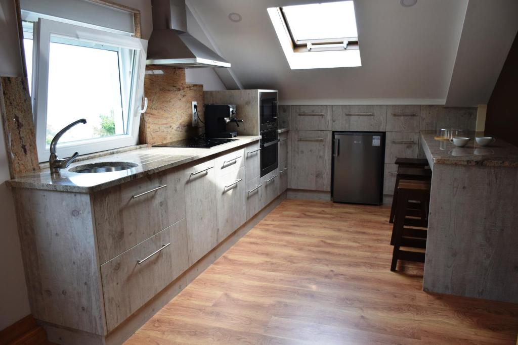 a large kitchen with a sink and a refrigerator at O Mencer do Camiño in Cee