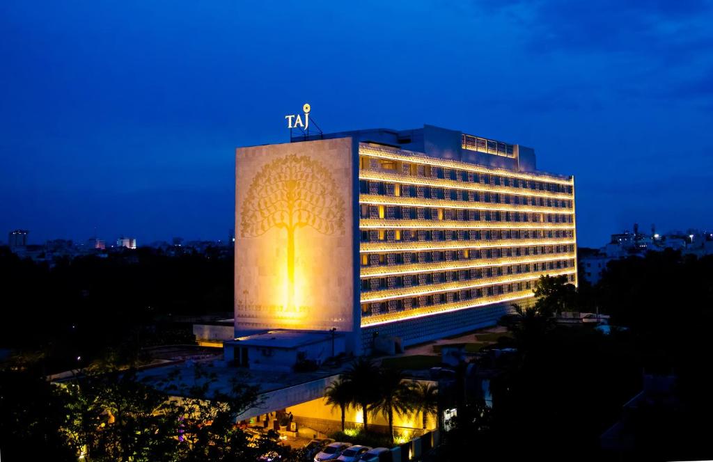 a large building with a lit up facade at night at Taj Coromandel in Chennai