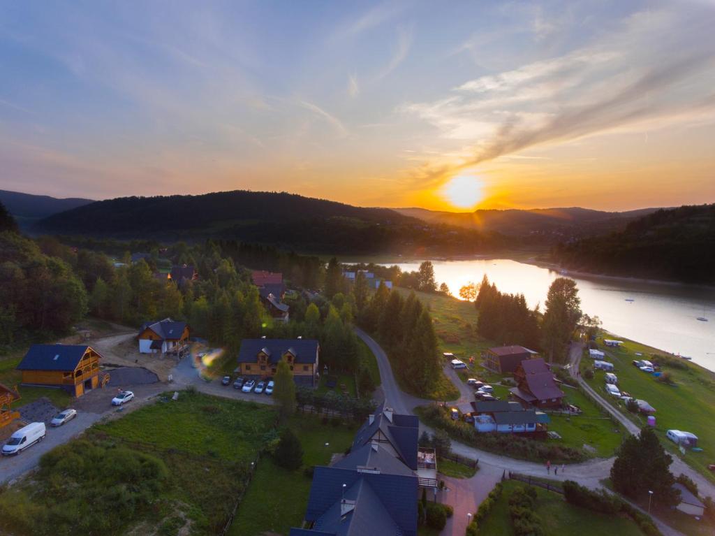 an aerial view of a resort with a river and the sunset at Bieszczadzka Zatoka in Zawóz