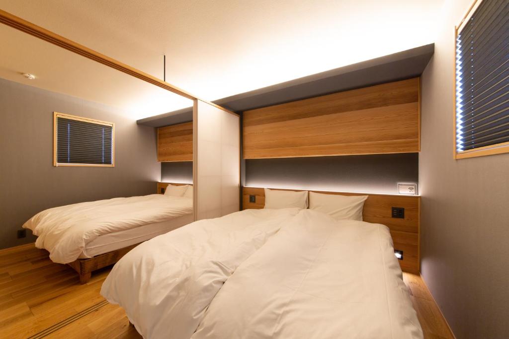 a bedroom with two beds and a mirror at KIKI HOTEL in Kanazawa