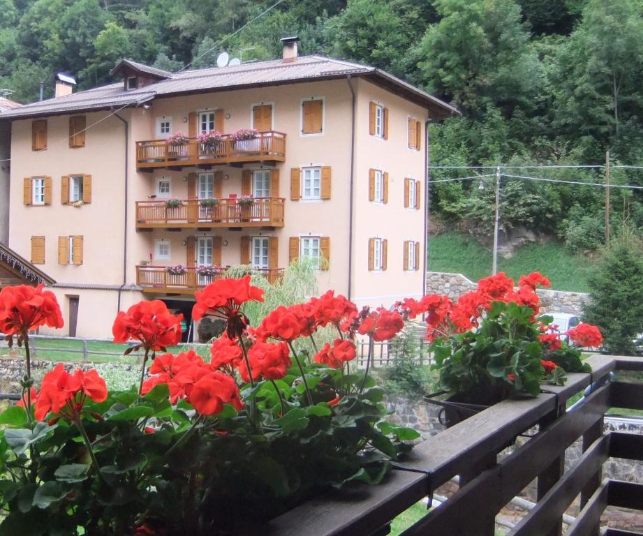 a building with red flowers in front of it at Appartamenti Acidule in Bagni di Rabbi