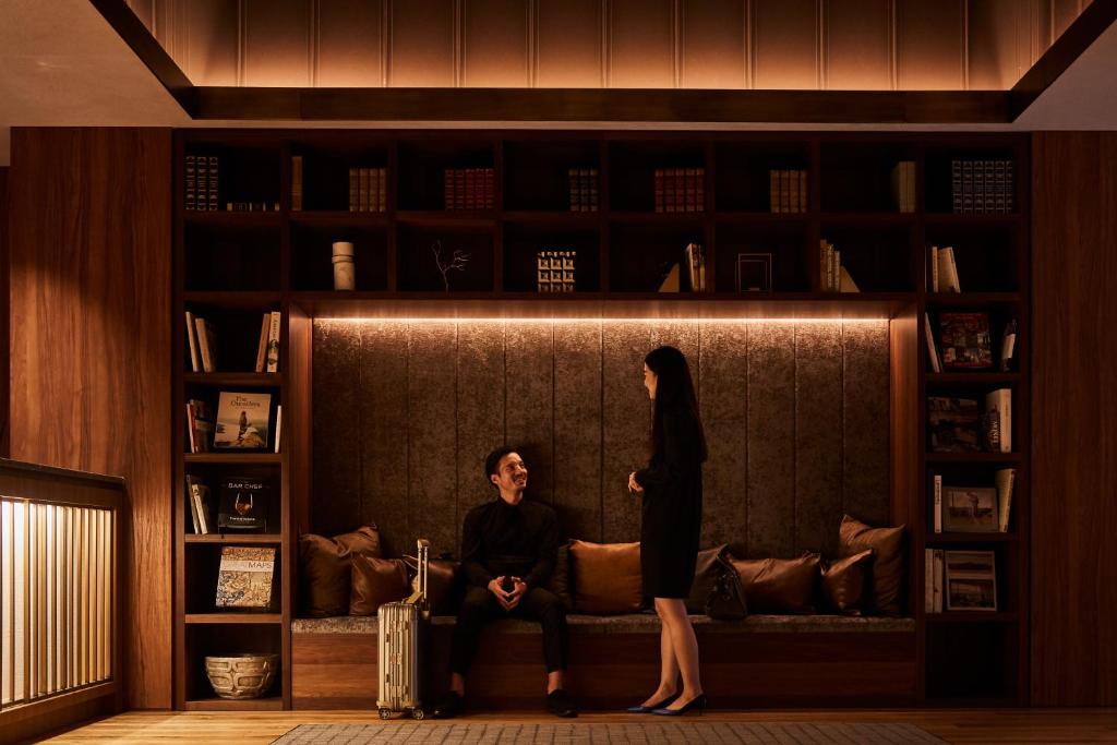 een vrouw die naast een vrouw op een bank staat bij Nest Hotel Tokyo Hanzomon in Tokyo
