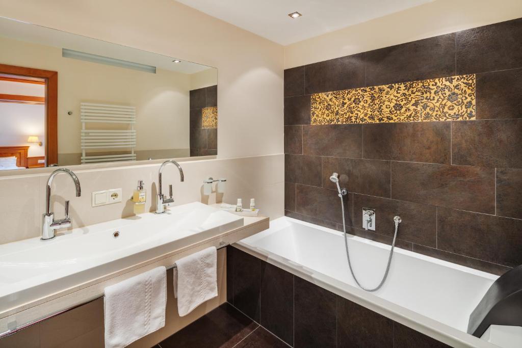 a bathroom with two sinks and a shower at Berg-Spa & Hotel Zamangspitze in Sankt Gallenkirch