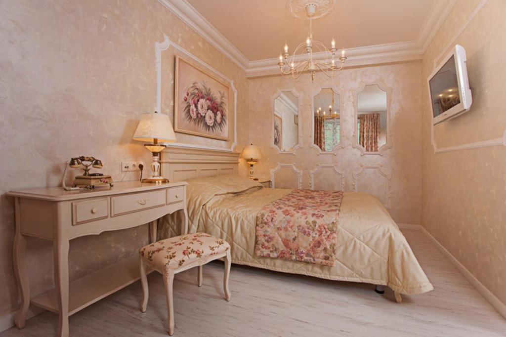 a bedroom with a bed and a dresser and a desk at Apart-hotel Arteparts in Krasnoyarsk