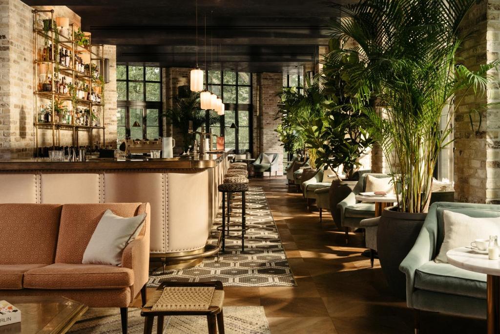a lobby with couches and a bar with plants at The Hoxton, Southwark in London
