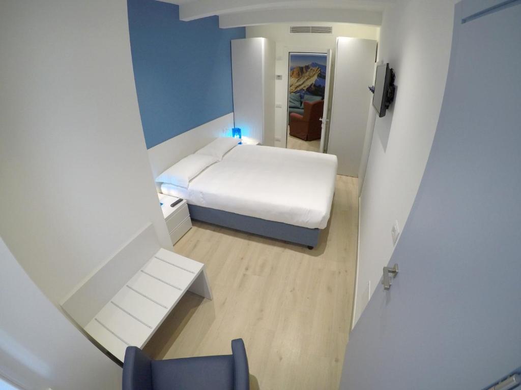 a small hospital room with a bed and a chair at La Casa sul Lago Lecco in Lecco