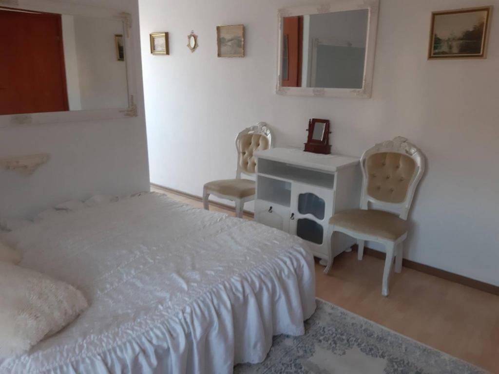 a bedroom with a bed and a desk and two chairs at Zajazd Ponikiew - Noclegi Wadowice in Wadowice