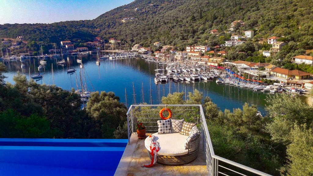 a balcony with a bed and a harbor with boats at Ktima Aniforeli Luxury Villas in Sivota