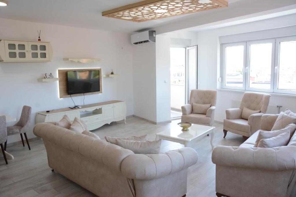 uma sala de estar com um sofá e cadeiras e uma televisão em HAMAM em Novi Pazar