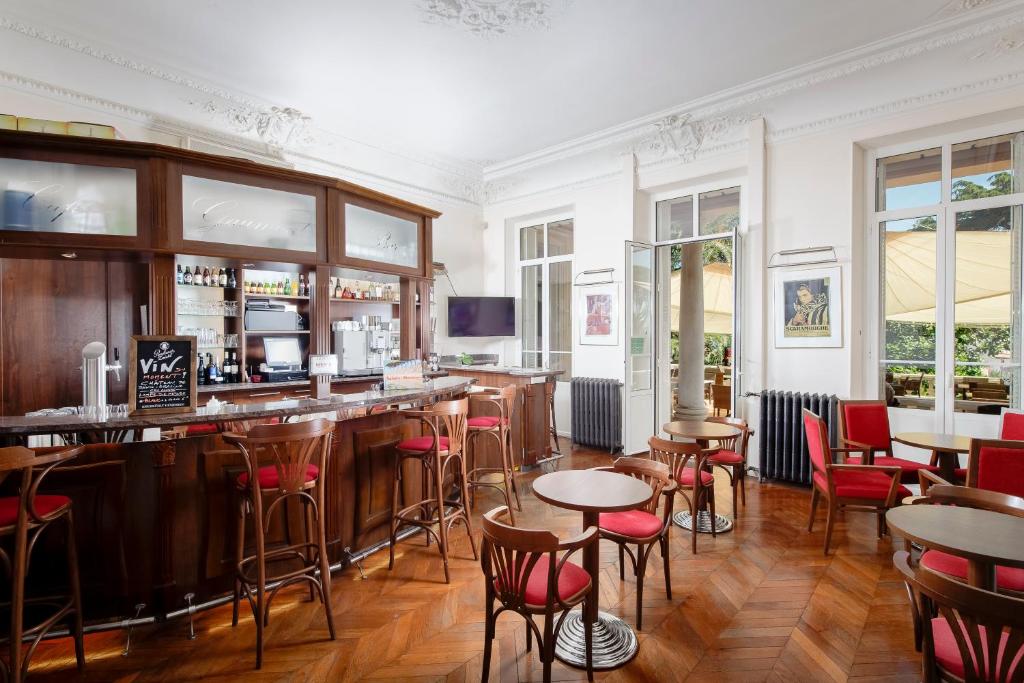 a bar in a restaurant with tables and chairs at Résidence les Tourelles in Sainte-Maxime