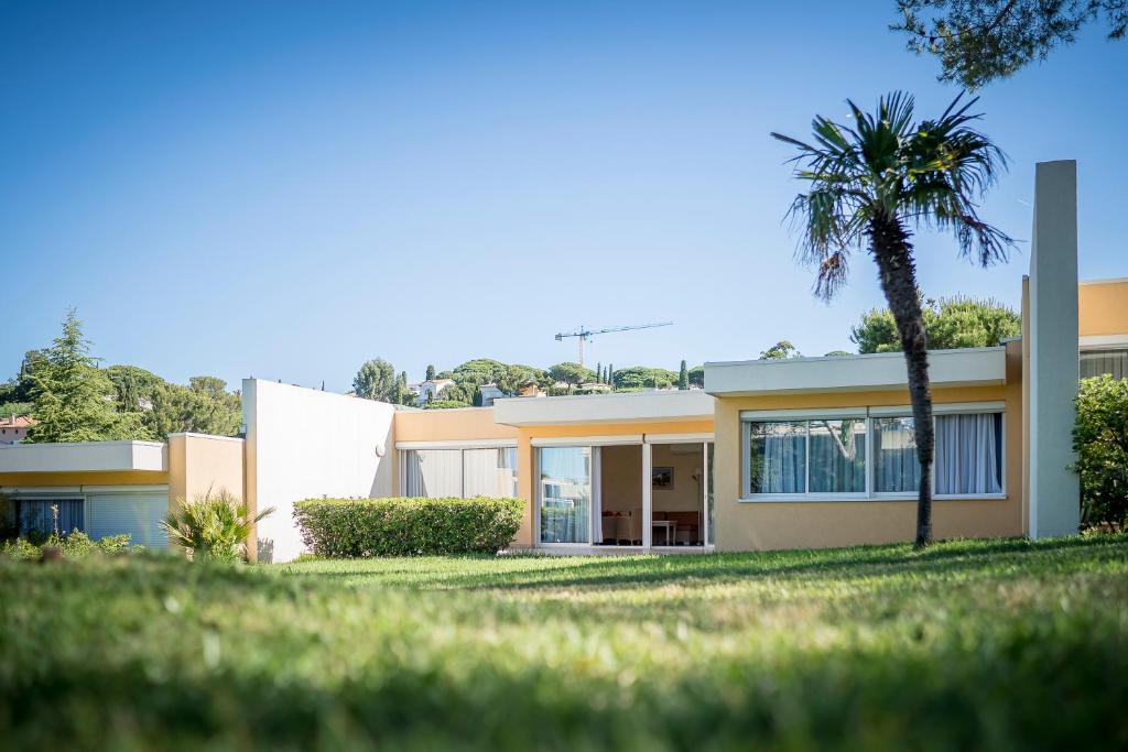 a house with a palm tree in front of it at Résidence les Tourelles in Sainte-Maxime